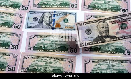 Ein Arrangement von US-Dollar-Scheinen mit fünfzig und hundert Dollar-Stückelungen und knackigen Geldscheinen, die die amerikanische Finanzwelt hervorheben Stockfoto