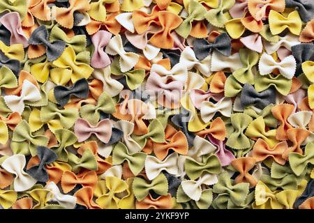 Ansicht von oben auf farbige Farfalle Pasta, natürlich gefärbt mit Kurkuma, Spinat, Rote Bete, Paprika und Tintenfisch. Die lebendigen Farben und die vielfältigen Farben der Pasta Stockfoto