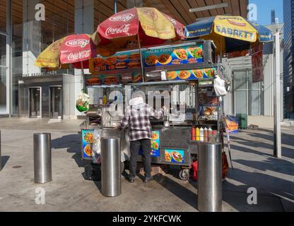 Ein Verkäufer, wahrscheinlich ein Immigrant, der einen Hotdog-Fast-Food-Stand in der 42nd Street in Midtown Manhattan betreibt. Stockfoto