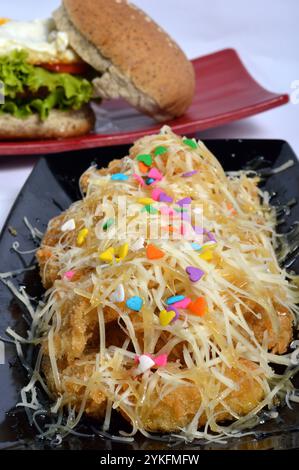 knusprig gebratene Bananen mit geriebenem Käse Stockfoto