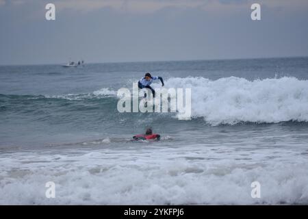 Laredo, Spanien, 18. November 2024: Surfer in weiß auf der Welle am 18. November 2024 am Strand La Salve in Laredo, Kantabrien, Spanien. Quelle: Javier Linares Misioner / Alamy Live News. Stockfoto