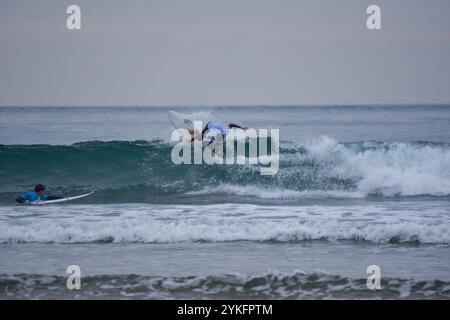 Laredo, Spanien, 18. November 2024: Der Surfer in weiß auf den Wellen, am 18. November 2024 am Strand La Salve in Laredo, Kantabrien, Spanien. Quelle: Javier Linares Misioner / Alamy Live News. Stockfoto