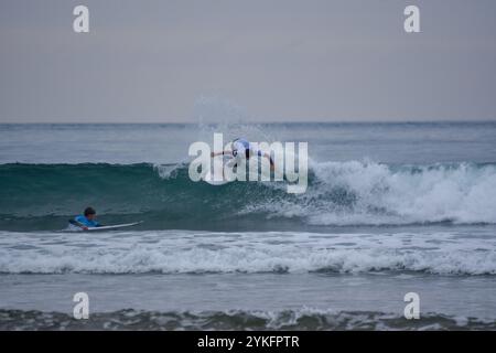 Laredo, Spanien, 18. November 2024: Der Surfer in weiß auf den Wellen, am 18. November 2024 am Strand La Salve in Laredo, Kantabrien, Spanien. Quelle: Javier Linares Misioner / Alamy Live News. Stockfoto