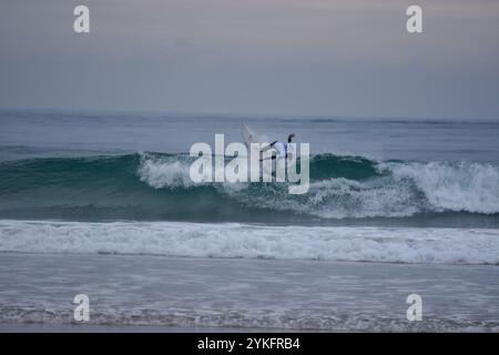 Laredo, Spanien, 18. November 2024: Surfer in weiß, der am 18. November 2024 am Strand La Salve in Laredo, Kantabrien, Spanien, eine Welle fängt. Quelle: Javier Linares Misioner / Alamy Live News. Stockfoto