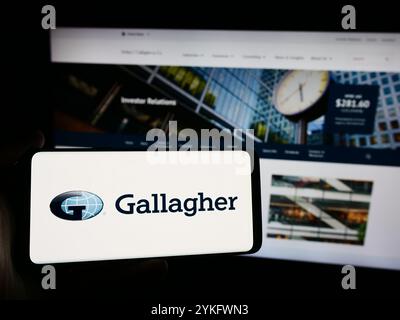 13. August 2024, Deutschland: In dieser Fotoabbildung hält ein Mann ein Smartphone mit dem Logo des US-Versicherungsunternehmens Arthur J. Gallagher Co. (AJG) vor der Website. (Credit Image: © Timon Schneider/SOPA Images via ZUMA Press Wire) NUR REDAKTIONELLE VERWENDUNG! Nicht für kommerzielle ZWECKE! Stockfoto