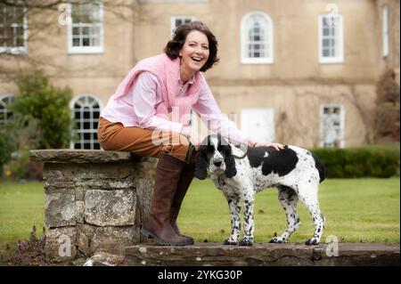 Eine Frau mittleren Alters saß und streichelte ihren älteren Cocker Spaniel Hund. Stockfoto