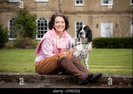 Eine Frau mittleren Alters saß und streichelte ihren älteren Cocker Spaniel Hund. Stockfoto