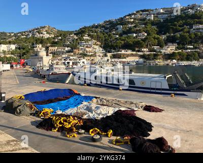 Hafenszene mit Fischernetzen, die in der Sonne trocknen, und Booten, die im Sommer am Ufer des Kais ankern Stockfoto