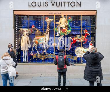 Mayfair, London, Großbritannien. November 2024. Weihnachtsdekorationen und Schaufensterdekorationen im Londoner Mayfair sorgen für Farbe an einem grauen Tag. Louis Vuitton Fenster in der New Bond Street. Quelle: Malcolm Park/Alamy Live News Stockfoto