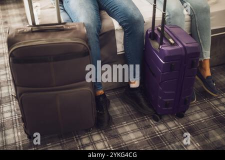 Nahaufnahme von Touristen, die auf dem Bett im Hotelzimmer liegen und ihre Koffer ausgepackt haben. Stockfoto