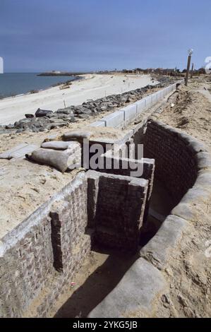 Erster Golfkrieg: 11. März 1991 ein verlassener irakischer Graben am Strand Ali Baba in Kuwait City. In der Erwartung, dass die Koalitionstruppen vom Meer aus einmarschieren, wurden Stacheldraht und Anti-Landungsboote am Strand und in den seichten Gewässern nahe der Küste aufgestellt. Auch die Strände wurden abgebaut. Stockfoto