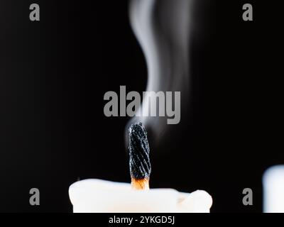 Kerzendocht raucht, nachdem er in der Dunkelheit gelöscht wurde Stockfoto