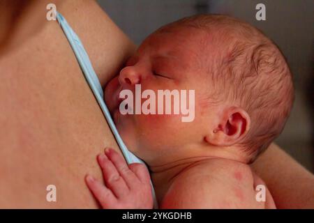 Schlafendes Baby, das nach der Pflege friedlich auf der Brust der Mutter ruht Stockfoto