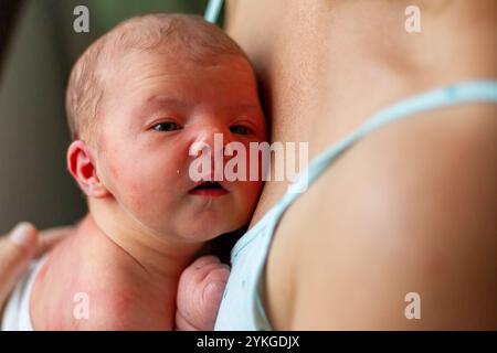 Schlafendes Baby, das nach der Pflege friedlich auf der Brust der Mutter ruht Stockfoto