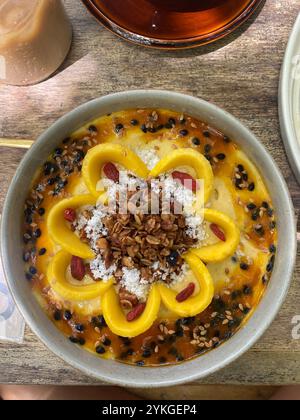 Mango Flower Smoothie Bowl mit frischem Joghurt, Samen und Kokosflocken, Honigsirup in einer kühlen und friedlichen Umgebung und einem köstlichen Brunch Stockfoto