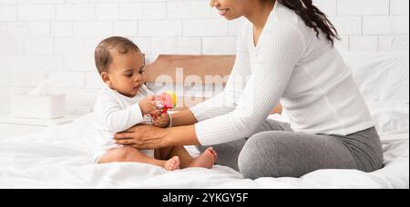 Schwarz Mutter Spielend Mit Baby Geben Spielzeug Sitzend Im Schlafzimmer Stockfoto