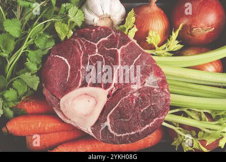Knöchel auf dem Knochen, rohes Fleisch für Ossobuco, mit Gemüse, in einem Korb, Zutaten zum Kochen Ossobuco, Blick von oben, keine Leute Stockfoto