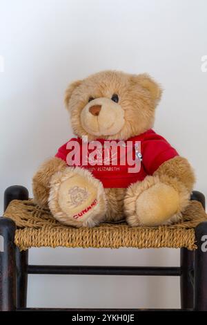 Cunard Teddybär weiches Kuscheltier mit rotem Queen Elizabeth Pullover Top auf Hocker - hergestellt in Indonesien, Keel Toys Stockfoto