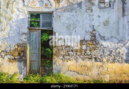 Alte verlassene, kaputte, beschädigte und schmutzige Häuser und Gebäude auf Rhodos in Griechenland Textur von einer Tür und einem Fenster Stockfoto
