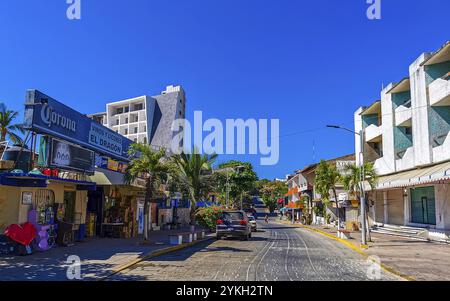 Puerto Escondido Oaxaca Mexiko 15. Februar 2023 typische schöne bunte Touristenstraße und Bürgersteig mit Stadtleben Autos Verkehrsgebäude heiß Stockfoto