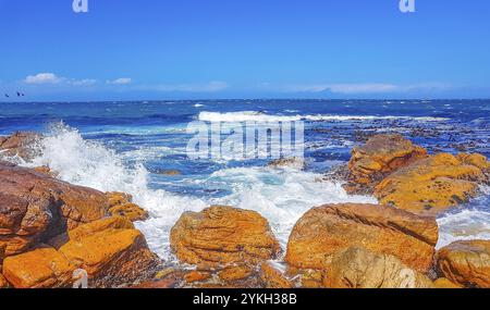 False Bay raue Küstenlandschaft mit Felsbrocken Wellen und Bergen mit Wolken in Glencairn Simons Town Kapstadt Westkap Südafrika Stockfoto