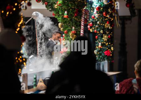Budapest, Ungarn - 15. November 2024: Vorosmarty-Weihnachtsmarkt. Ein Verkäufer, der Glühwein auf Budapests festlichem Markt rührt Stockfoto