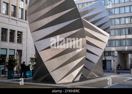 Am 8. Oktober 2024 in London, Großbritannien, spazieren die Menschen vorbei an Paternoster Vents, einer großen öffentlichen Skulptur am Paternoster Square in der City of London. Paternoster Vents, auch bekannt als Angels Wings des Künstlers Thomas Heatherwick, ist eine Skulptur aus Edelstahl aus dem Jahr 2002, die auf der Paternoster Lane installiert wurde. Die Skulptur dient der Belüftung einer unterirdischen elektrischen Unterstation. Stockfoto