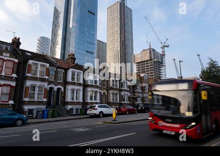 Ein neuer Hochhauswohnblock ragt am 5. November 2024 in London, Großbritannien, über einer alten Terrasse mit flachen Häusern im Herzen des Finanzviertels Canary Wharf. Canary Wharf ist ein Gebiet in der Nähe der Isle of Dogs im London Borough of Tower Hamlets und wird von der Greater London Authority als Teil des zentralen Geschäftsviertels von London definiert. Zusammen mit der City of London ist sie eines der wichtigsten Finanzzentren im Vereinigten Königreich und der Welt, mit vielen Hochhäusern. In den letzten Jahren und mit dem Wandel der Arbeitspraktiken von der Büroarbeit zu hybriden und r Stockfoto