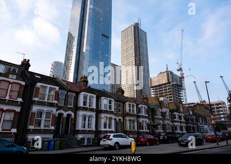 Ein neuer Hochhauswohnblock ragt am 5. November 2024 in London, Großbritannien, über einer alten Terrasse mit flachen Häusern im Herzen des Finanzviertels Canary Wharf. Canary Wharf ist ein Gebiet in der Nähe der Isle of Dogs im London Borough of Tower Hamlets und wird von der Greater London Authority als Teil des zentralen Geschäftsviertels von London definiert. Zusammen mit der City of London ist sie eines der wichtigsten Finanzzentren im Vereinigten Königreich und der Welt, mit vielen Hochhäusern. In den letzten Jahren und mit dem Wandel der Arbeitspraktiken von der Büroarbeit zu hybriden und r Stockfoto