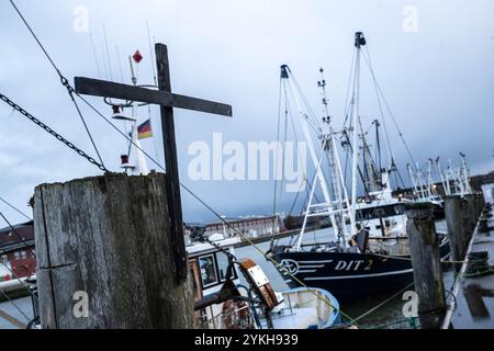 Cuxhaven, Deutschland. November 2024. Ein Kreuz wird am Hafen vor den Garnelenbooten platziert. Die 2. Norddeutsche Fischereikonferenz findet in Cuxhaven statt. Thema der Konferenz ist die Sicherung und nachhaltige Entwicklung der deutschen Küstenfischerei. Quelle: Sina Schuldt/dpa/Alamy Live News Stockfoto