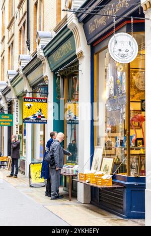 Leute, die sich Antiquitätenbücher und Kunstgeschäfte in Cecil Court, London, anschauen Stockfoto