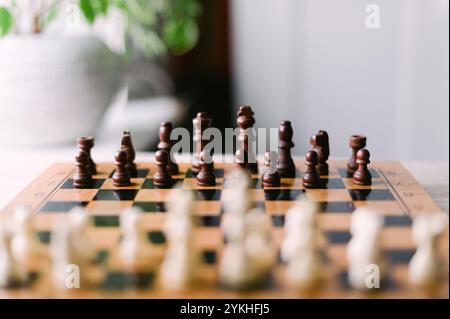 Ein Schachbrett mit Stücken drauf. Die Platine ist schwarz-weiß. Die Stücke sind so angeordnet, dass sie bereit sind, ein Spiel zu spielen Stockfoto