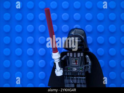 Tambow, Russische Föderation - 14. November 2024 Porträt der Minifigur Lego Darth Vader mit Lichtschwert vor blauem Hintergrund Stockfoto