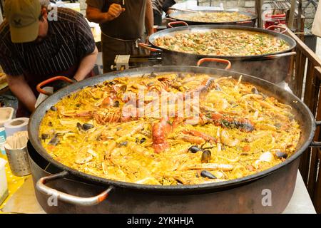 Große, dampfende Pfanne mit Meeresfrüchten, die von Küchenchefs auf einem Street Food Market in Edinburgh, Schottland, zubereitet werden Stockfoto