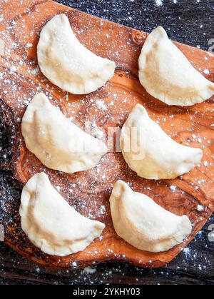 Roher Knödel mit Kartoffeln. Bereiten Sie die Knödel auf dem hölzernen Brett vor. Stockfoto