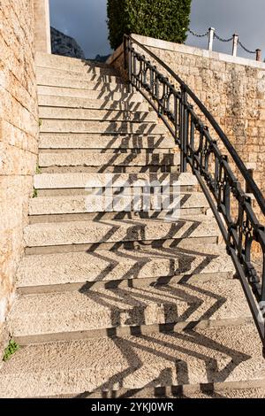 Schmiedeeisernes Geländer mit Betontreppen. Eisengeländer. Elemente Geländer, Steintreppe mit Stahlhandlauf. Modernes Treppenhaus Stockfoto