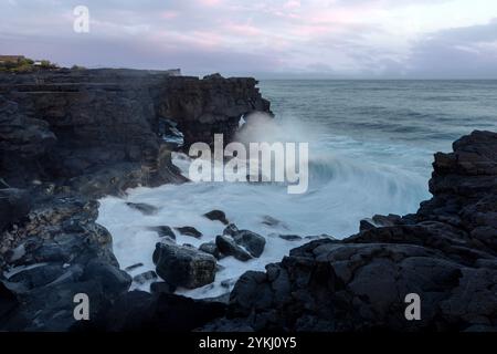 Cabrito auf der Insel Pico auf den Azoren hat einen Badebereich aus schwarzer Lava mit traditionellen Lavasteinhäusern mit Blick auf den majestätischen Mount Pico. Stockfoto