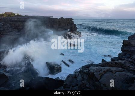 Cabrito auf der Insel Pico auf den Azoren hat einen Badebereich aus schwarzer Lava mit traditionellen Lavasteinhäusern mit Blick auf den majestätischen Mount Pico. Stockfoto