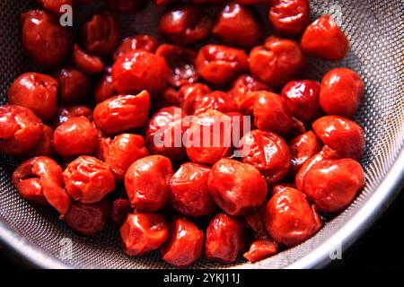 Frische Kirschen werden in einem Sieb gebohrt. Stockfoto