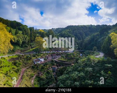Ribeira dos Caldeiroes. Drohnenblick auf die kleine Stadt neben Cascata da Ribeira dos Caldeiroes.in Sao Miguel, Azoren Berge Stockfoto