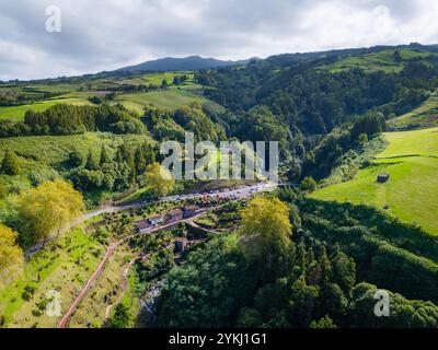 Cascata da Ribeira dos Caldeiroes. Drohnenansicht auf eine kleine Stadt in Sao Miguel, Azoren Berge Stockfoto