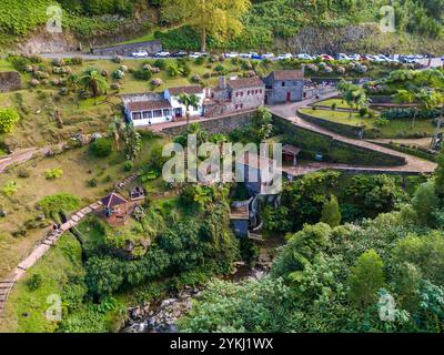 Ribeira dos Caldeiroes. Drohnenblick auf die kleine Stadt neben Cascata da Ribeira dos Caldeiroes.in Sao Miguel, Azoren Berge Stockfoto