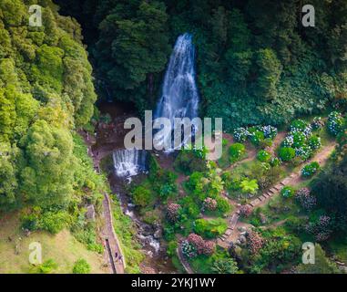 Cascata da Ribeira dos Caldeiroes. Drohnenansicht auf eine kleine Stadt in Sao Miguel, Azoren Berge Stockfoto