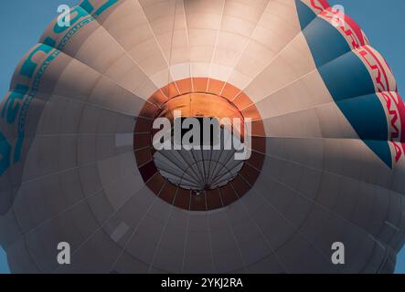Farbenfrohe Heißluftballons, die während einer lebhaften Ballonfahrt am klaren blauen Himmel schweben und Abenteuer, Freiheit und Outdoor-Freizeitaktivitäten zeigen Stockfoto
