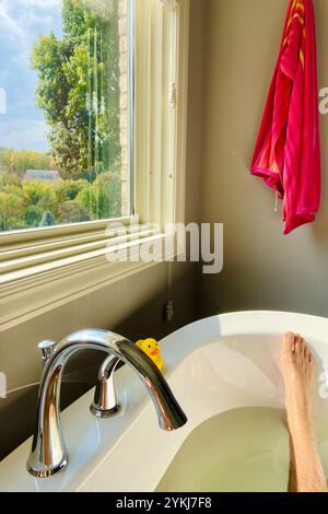 Entspannen Sie sich in der Jacuzzi-Badewanne unter einem großen Fenster, wunderschöner Sommerblick Stockfoto