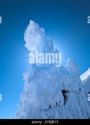 Gefrorene, eisbedeckte Funkantenne auf einem hohen Berg Stockfoto