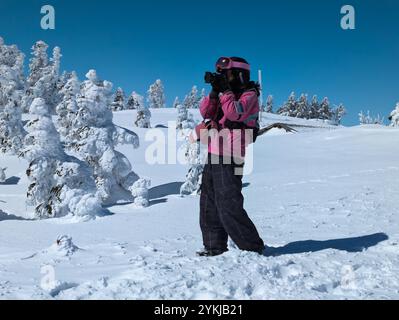 Snowboarderin fotografiert eine gefrorene Waldlandschaft an einem klaren Wintertag (Shibutoge, Japan) Stockfoto