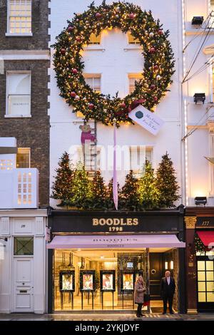 London, Großbritannien. November 2024. Boodles in der Old Bond Street und ein beleuchteter Kranz. Weihnachtslichter, Kugeln und raffinierte Dekorationen wurden entlang der Bond Street und ihren Luxusläden, Piccadilly, Burlington Arcade und ganz Mayfair in Erwartung der hektischen Weihnachtseinkaufszeit aufgestellt. Quelle: Imageplotter/Alamy Live News Stockfoto