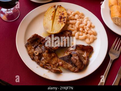 Gebratenes Lamm mit Bohnen und halber Kartoffel. Stockfoto