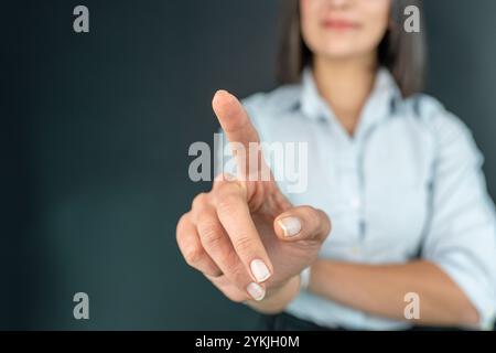 Geschäftsfrau berührt Konzepte im Studio. Geschäftsfrau, die auf eine Touchscreen-Oberfläche drückt Stockfoto